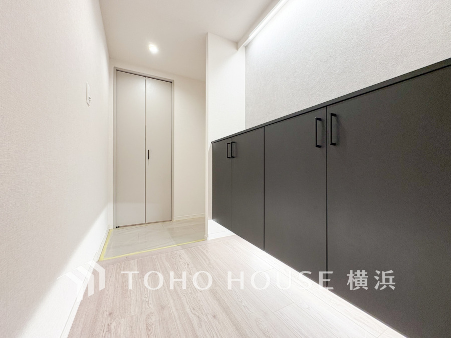 玄関ホールは壁付けの収納でスッキリ片付き、足元の間接照明が上質な空間を演出します。