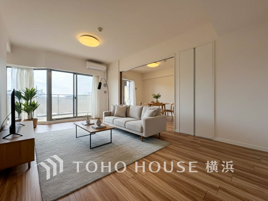 大きな窓から自然光が差し込む明るいリビング。広々19帖の空間です。（家具・装飾品はAI加工です）