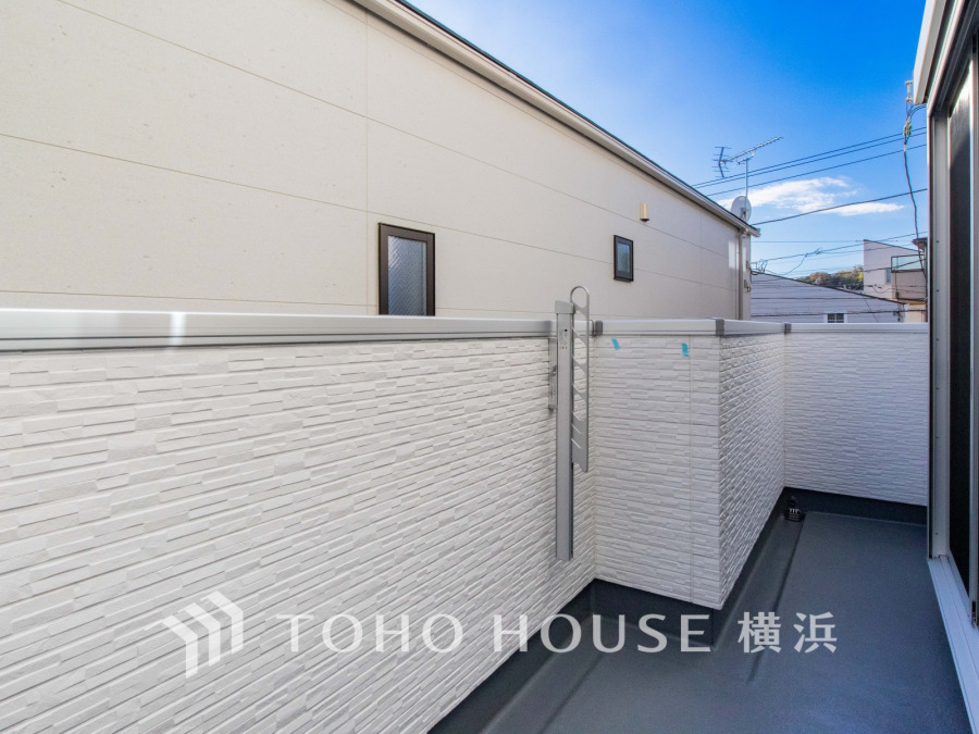 清潔感あふれるホワイトのタイル壁と広々としたスペースが魅力のバルコニーで、快適なアウトドアライフを実現します。