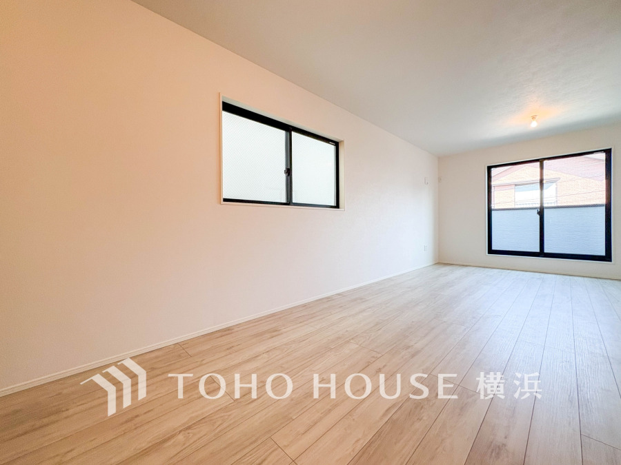 明るい自然光が差し込む、広々としたシンプルなリビング空間。ナチュラルなフローリングで温かみのある住まいです。