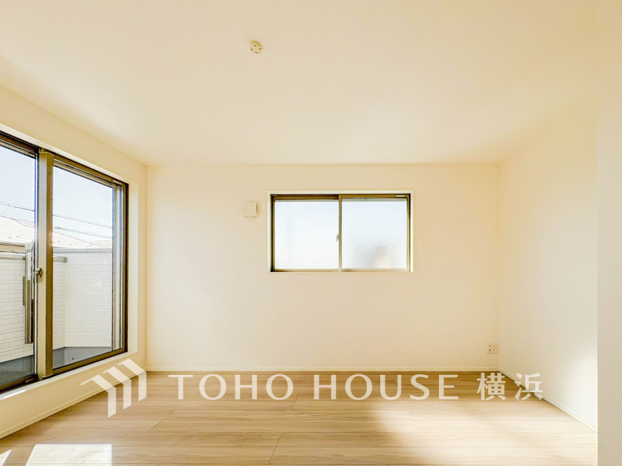 大きな窓から自然光が差し込む、明るく開放的なリビング空間。シンプルで使いやすいデザインです。